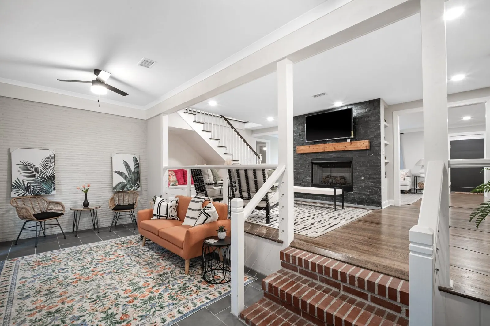 Completed interior with painted brick accent wall, fireplace surround and finished ceiling in a rebuilt home